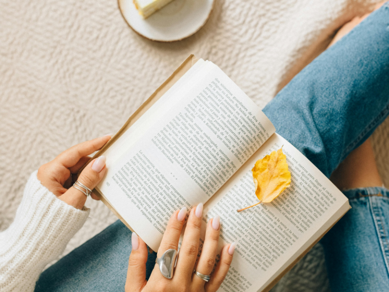 woman reading a book with some dessert