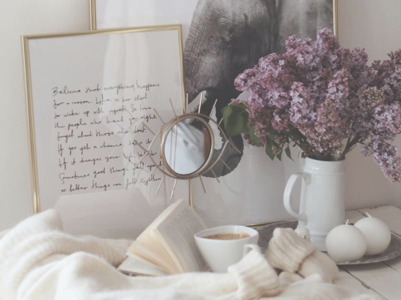 vase with flowers, coffee mug, books and pictures