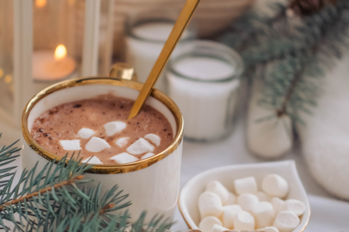 Cozy hot chocolate in a gold rimmed mug packed with marshmallows