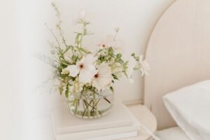 clear vase on bedside table with flowers